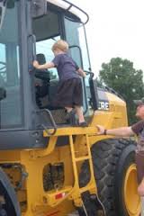 Franklin Tennessee Touch a Truck event showing a little boy climbing in a large yellow tractor truck.