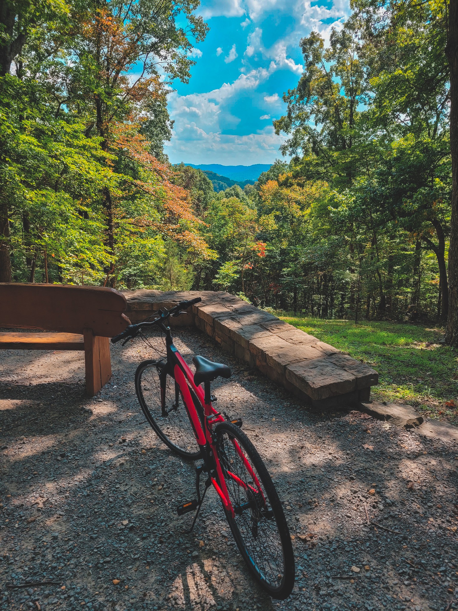 Bicycle parked at a scenic overlook in Percy Warner Park with wooded hills and a blue sky in the distance.