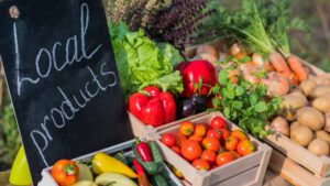 Local Franklin, Williamson County, TN Farmers Market, counter with fresh vegetables and a sign of local products.