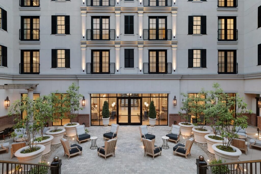 The Harpeth Hotel courtyard patio in downtown Franklin, TN, featuring outdoor seating, lounge chairs, and landscaped planters.