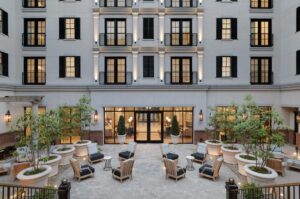 The Harpeth Hotel courtyard patio in downtown Franklin, TN, featuring outdoor seating, lounge chairs, and landscaped planters.