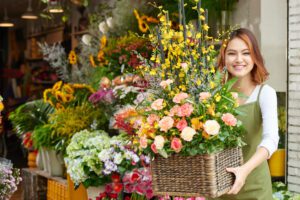 Florist in Nolensville, TN holding a flower arrangement for sale.