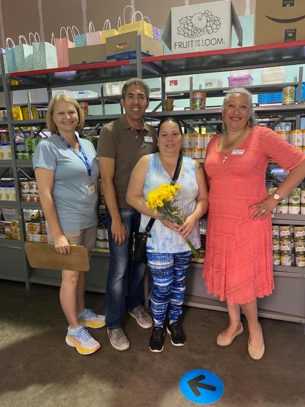 Maria Lorraine Quinones (holding flowers) recently received GraceWorks’ 10,000th food cart. With her are, from left, GraceWorks volunteer Lainie Anderson, food distribution manager Mark Short and Nina Reyes, food distribution assistant manager.