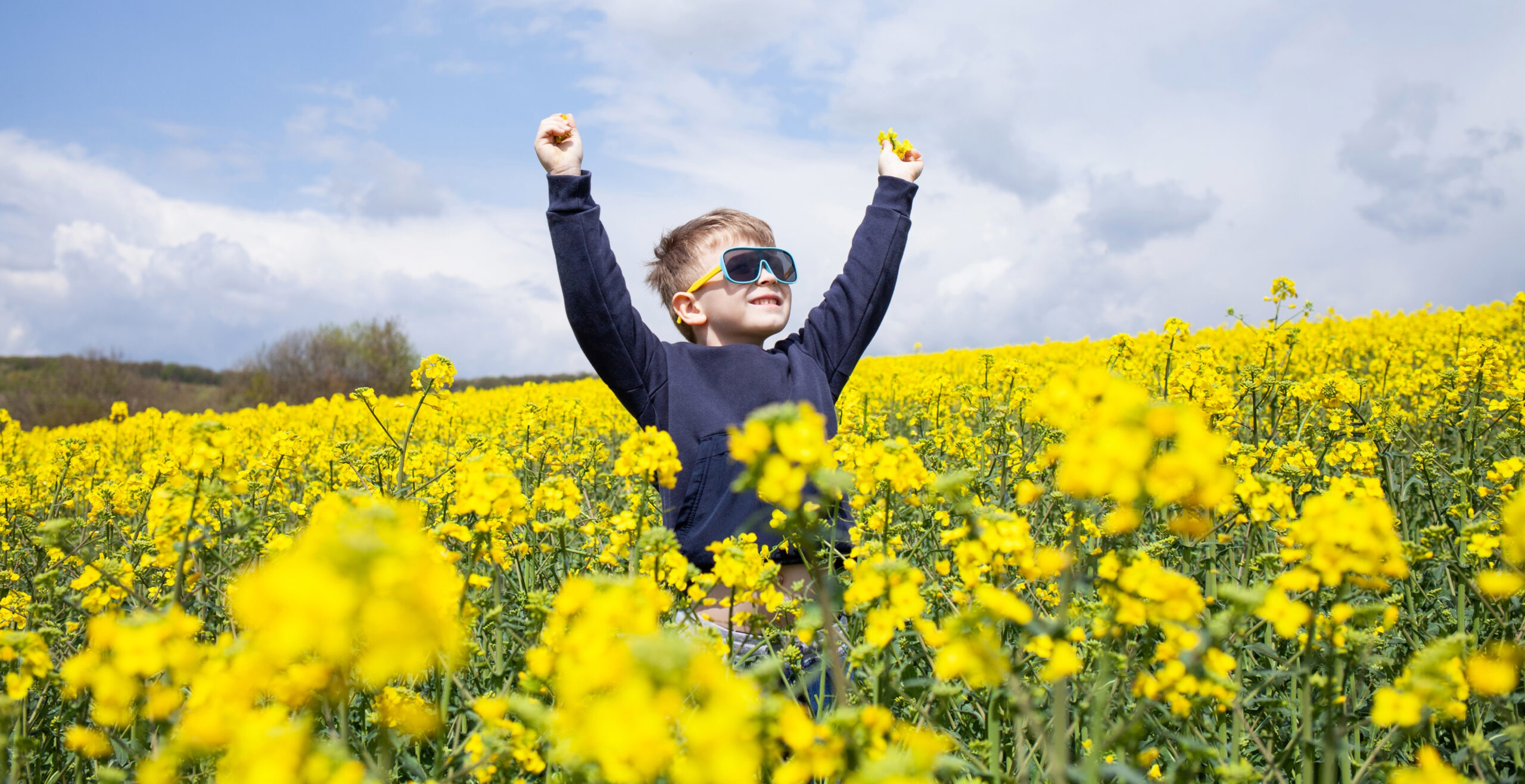 Young boy wearing sunglasses in spring flower field
