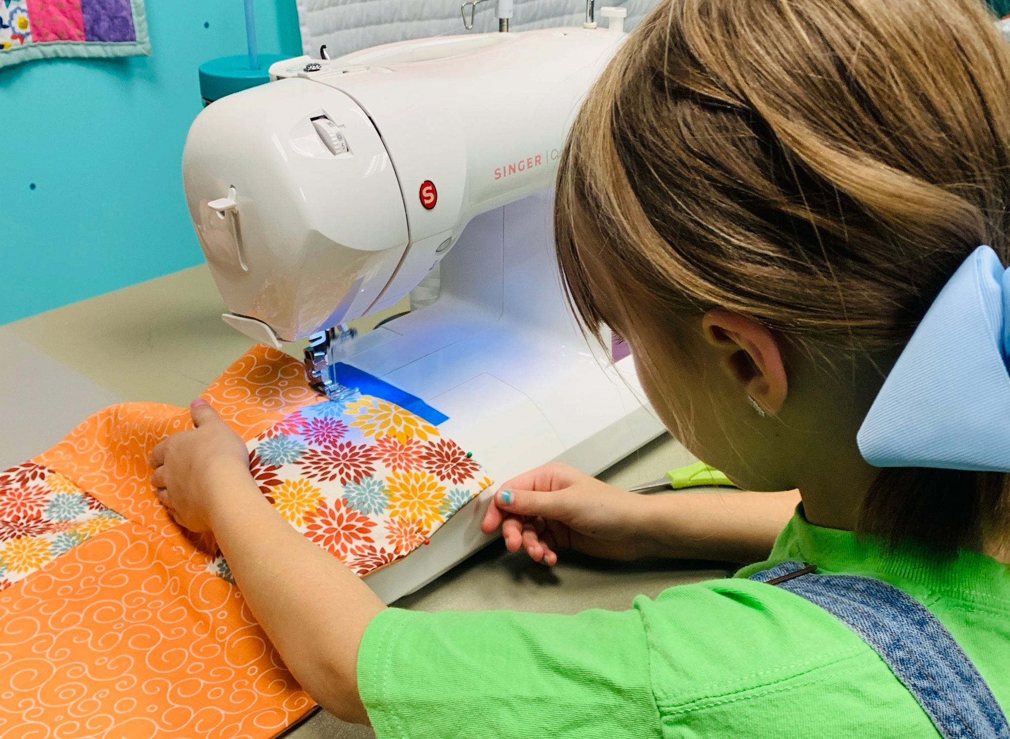 Girl sewing at sewing machine.