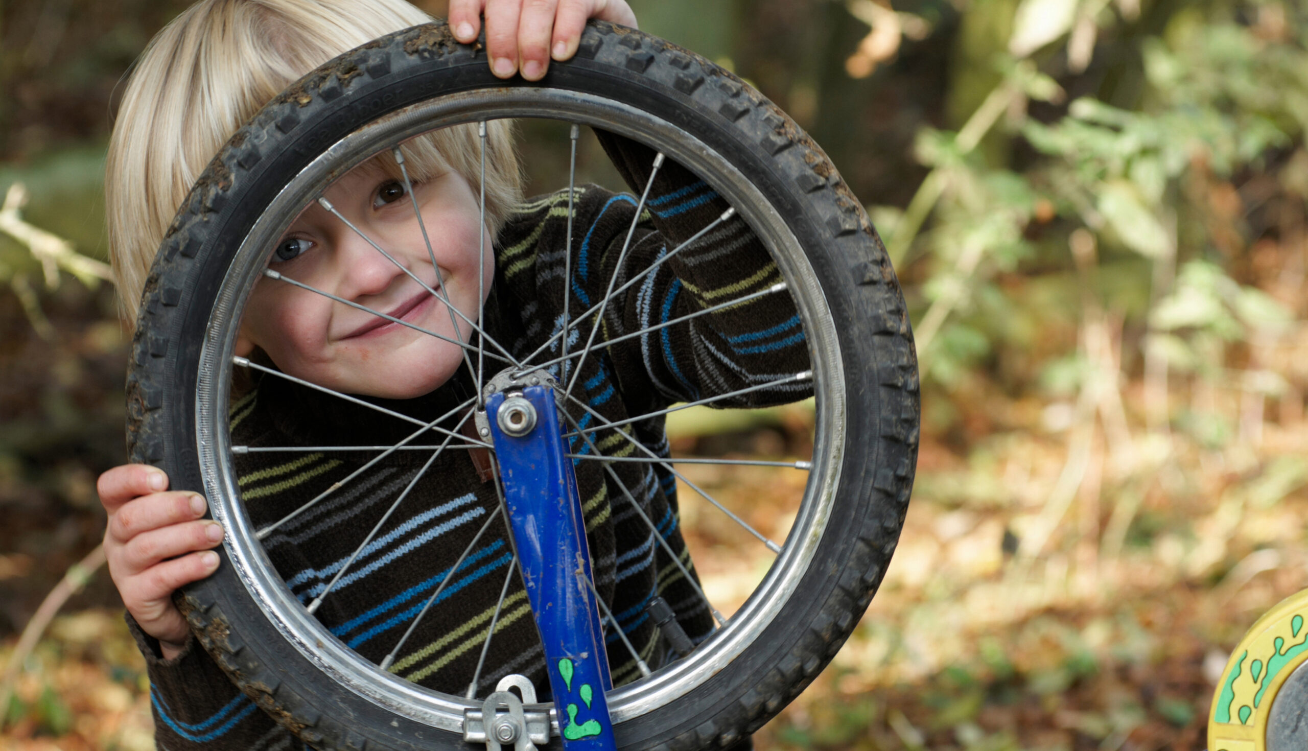 Boy looking through bike wheel