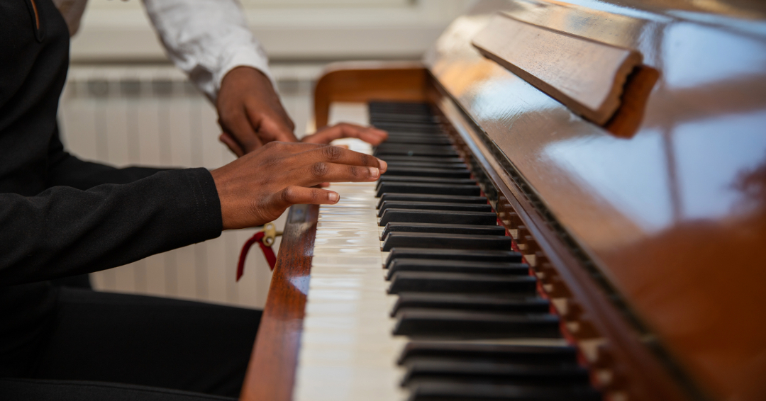 Music classes in Franklin, Brentwood and Williamson County, TN, hands hover over piano keys, a teacher in the rearview of the picture.