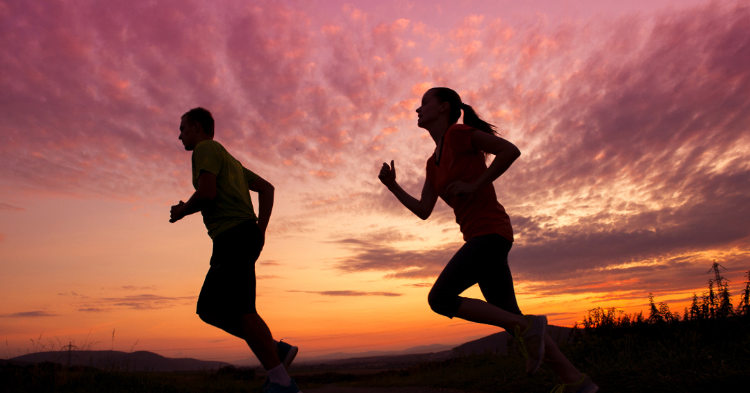 The shadows of a man and a woman are running at sunset. 