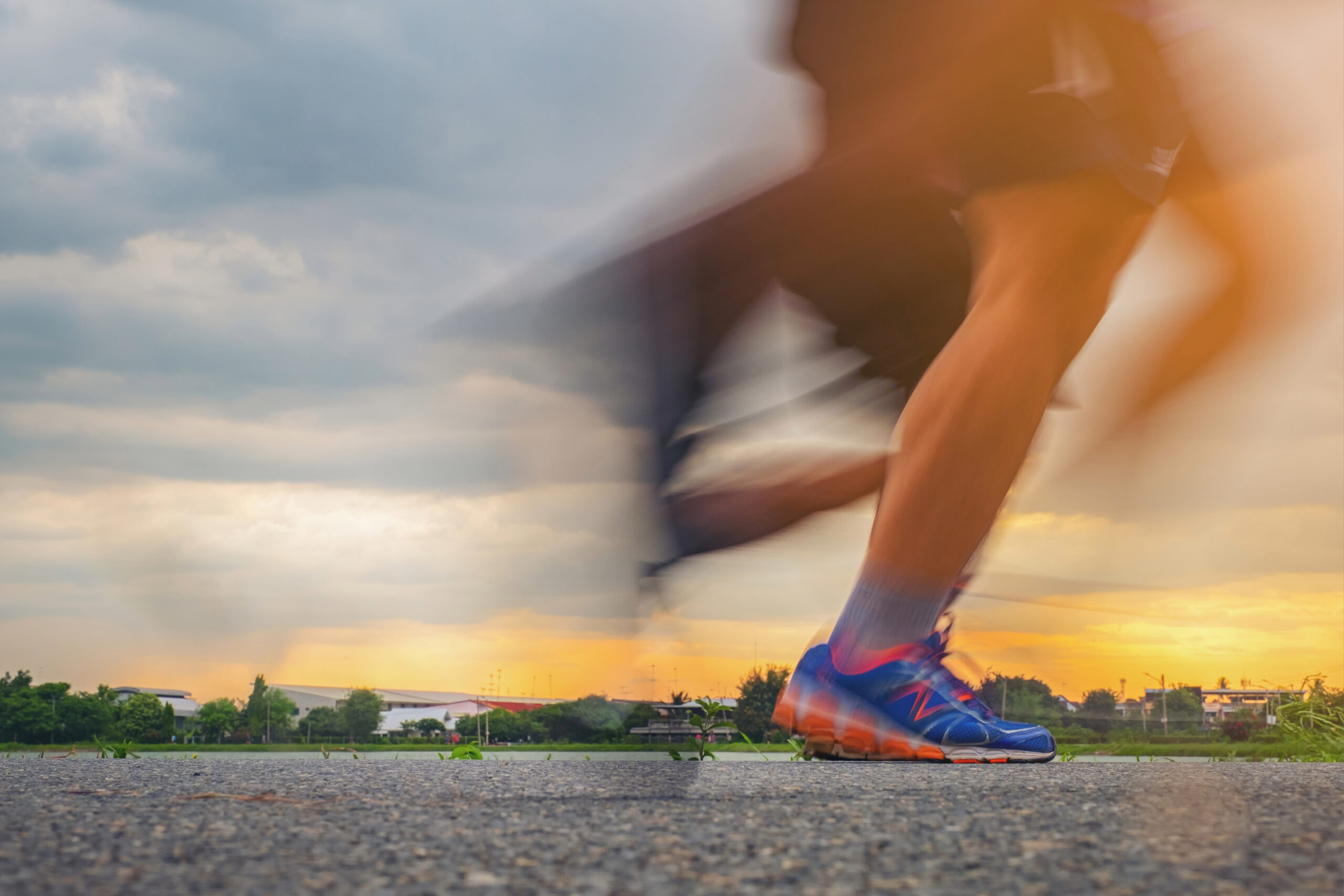 Blurry feet, running on asphalt.