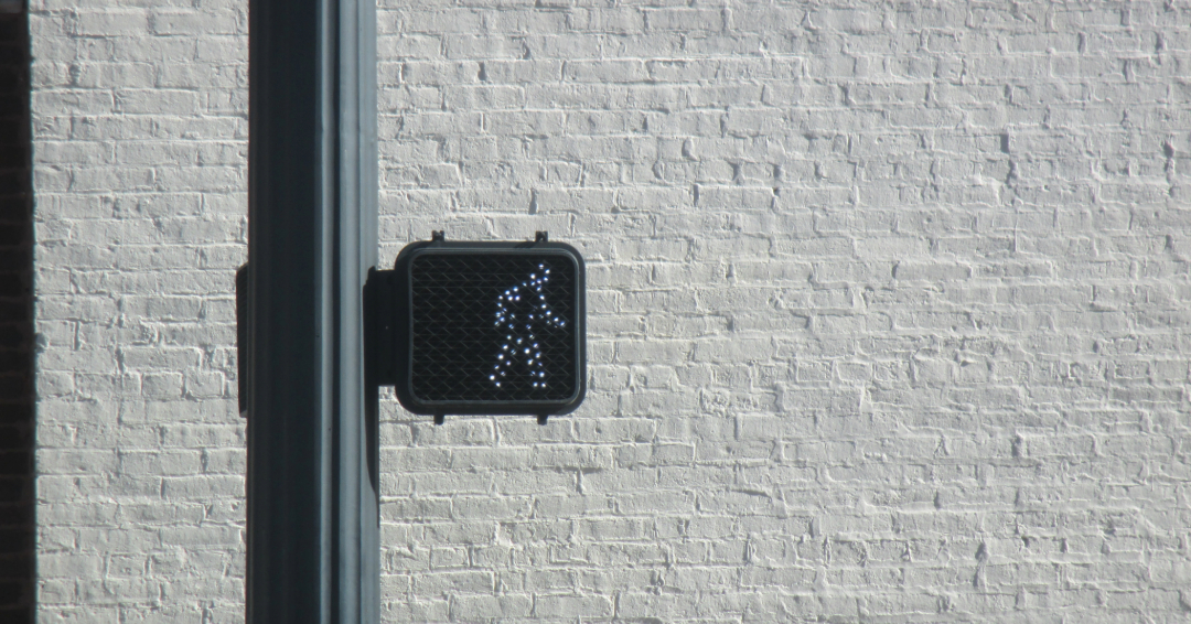 light up walk sign, white brick background 