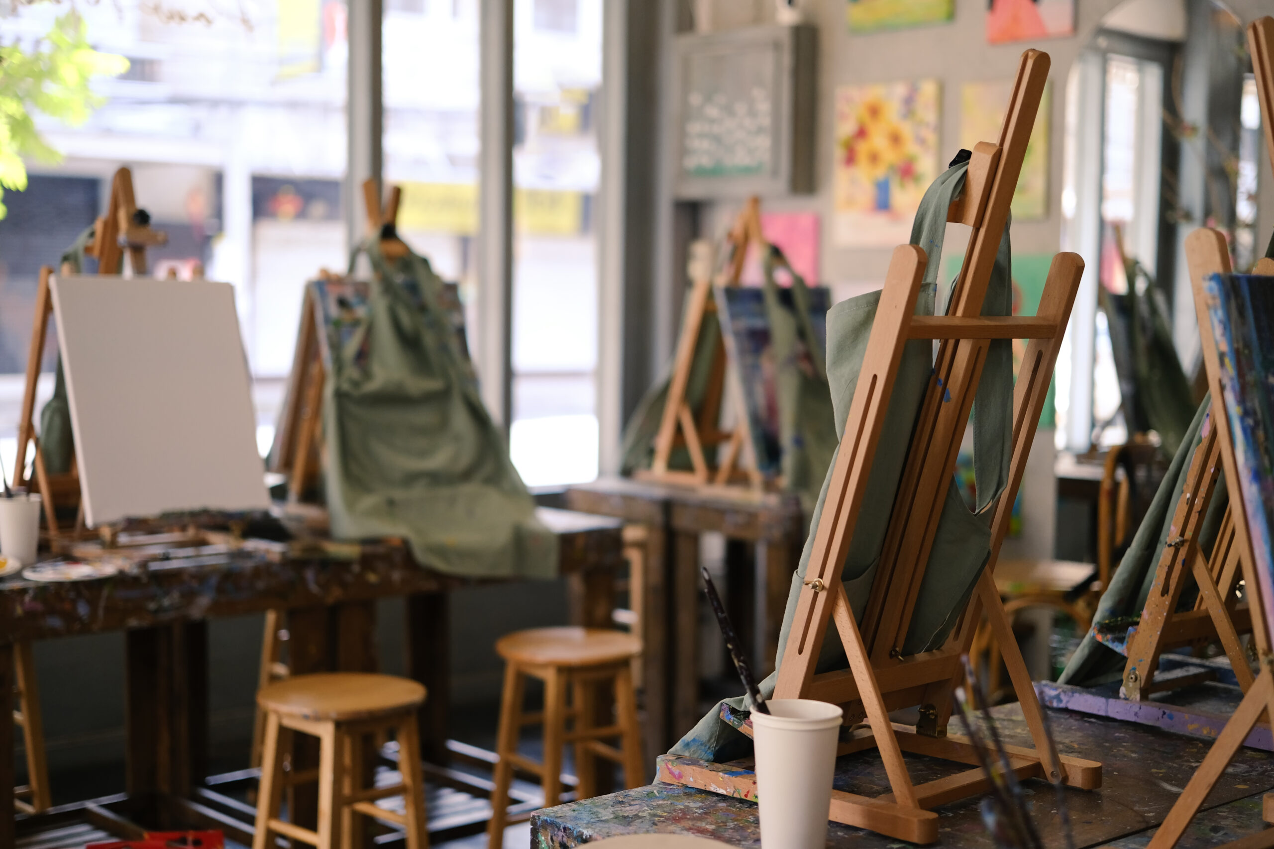 Interior of the creative art workshop with wooden easels and painting equipment.