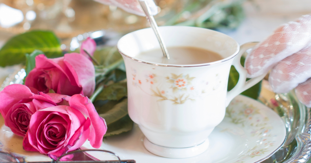 Pretty Lovely Teas serves Davidson and Williamson County, Tennessee, bringing the classic British tea party right to your doorstep, a woman's lace-gloved hands stir milk into tea.