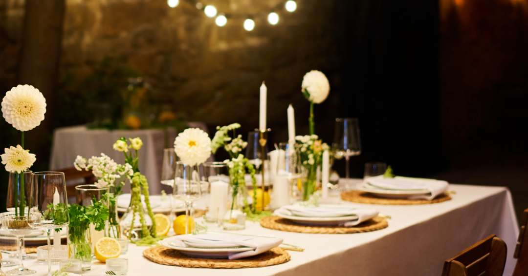 A table set with place settings and flowers. 