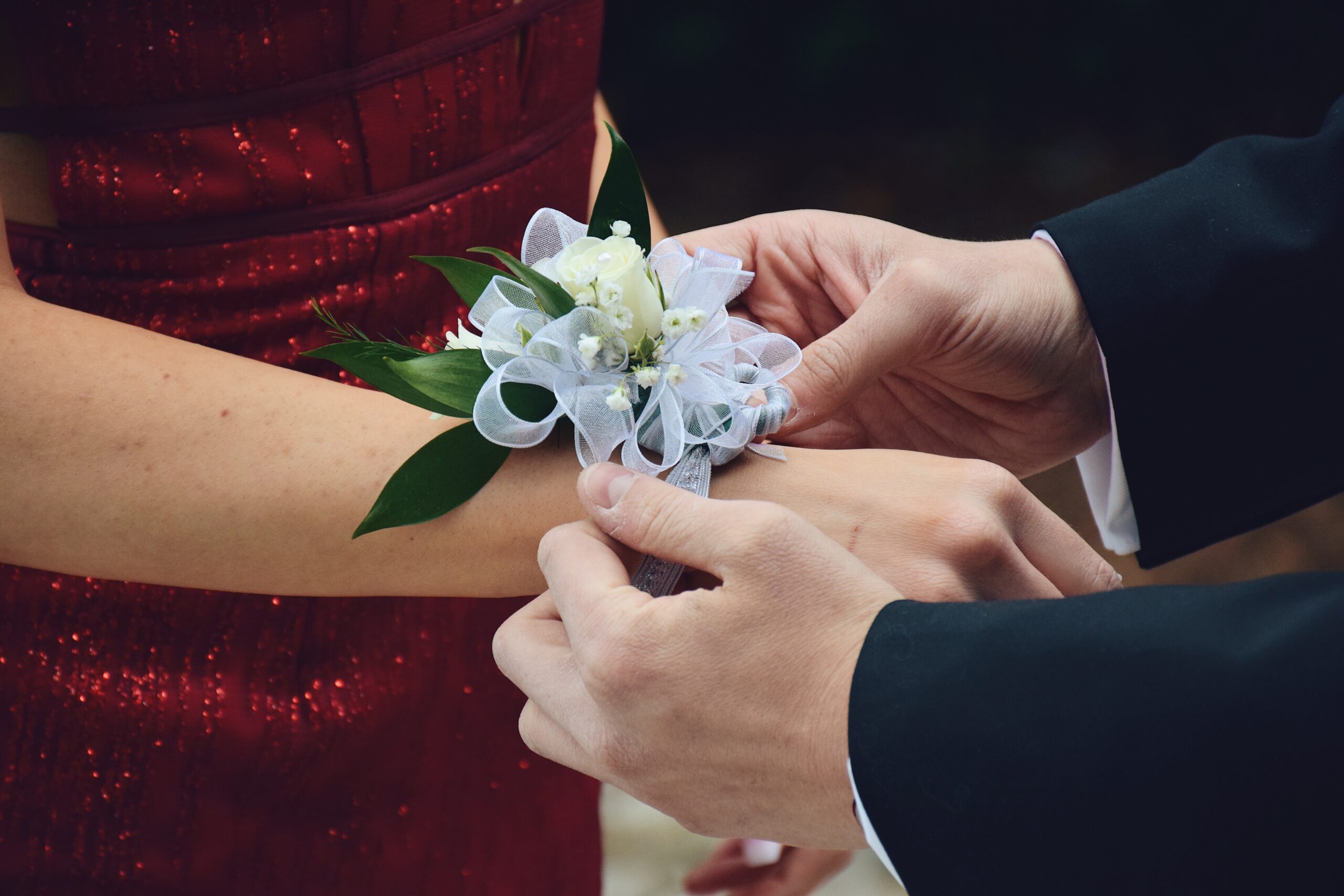 A corsage from a Franklin florist, being put on a wrist before prom.