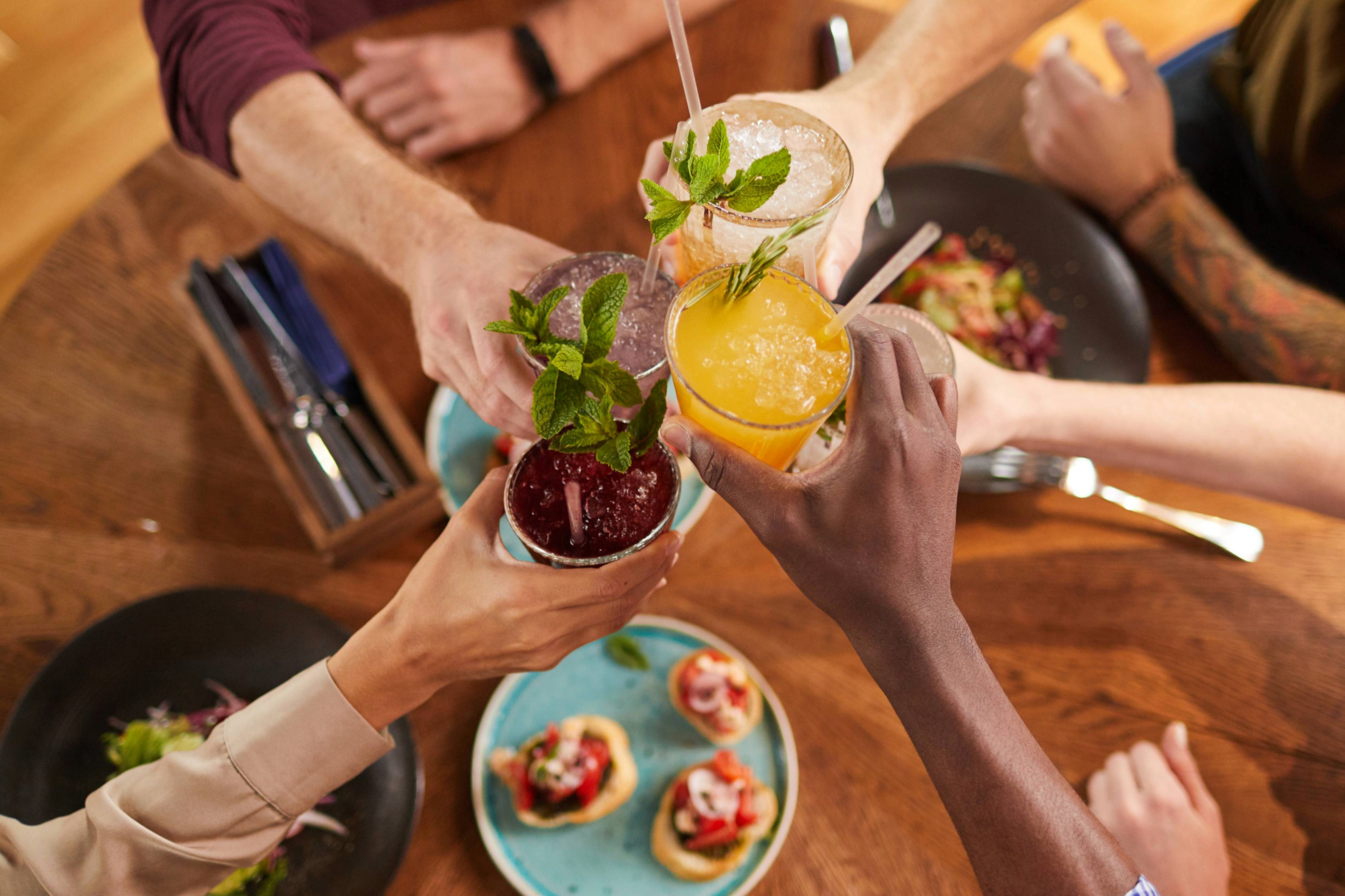 Friends cheers over food and drinks, enjoying happy hour in Franklin, Tennessee.