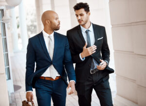 Menswear in Franklin and Brentwood, TN, two men in tailored suits outside a downtown building, showcasing professional style and modern business attire.