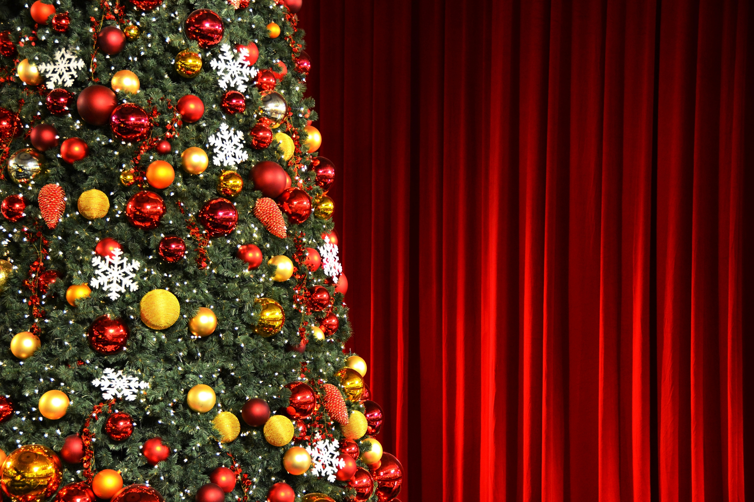 Decorated Christmas tree on a red curtained stage