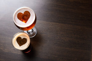 Hoppy Valentines Celebration in Franklin, TN, at Curio Brewing, heart silhouettes in two glasses of fresh beer on table, view from above