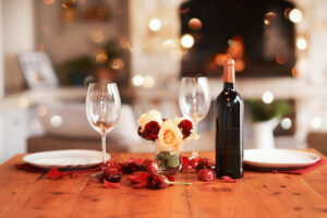 Romantic, dinner table and setup for Valentines day, fine dining or date at indoor night restaurant. Interior diner with wine glasses prepared with roses and champagne for evening couple reservation in Franklin, Tennessee.