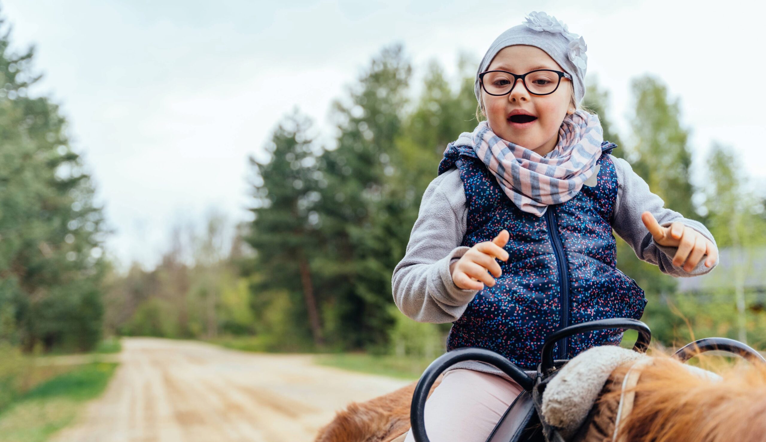 Therapeutic and special needs services for children in Williamson County, TN, represented by a young child participating in an assisted horseback riding activity outdoors.