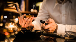 Single Malt Cigar Bar in Nashville’s Wedgewood-Houston neighborhood, man lights a cigar at the bar.
