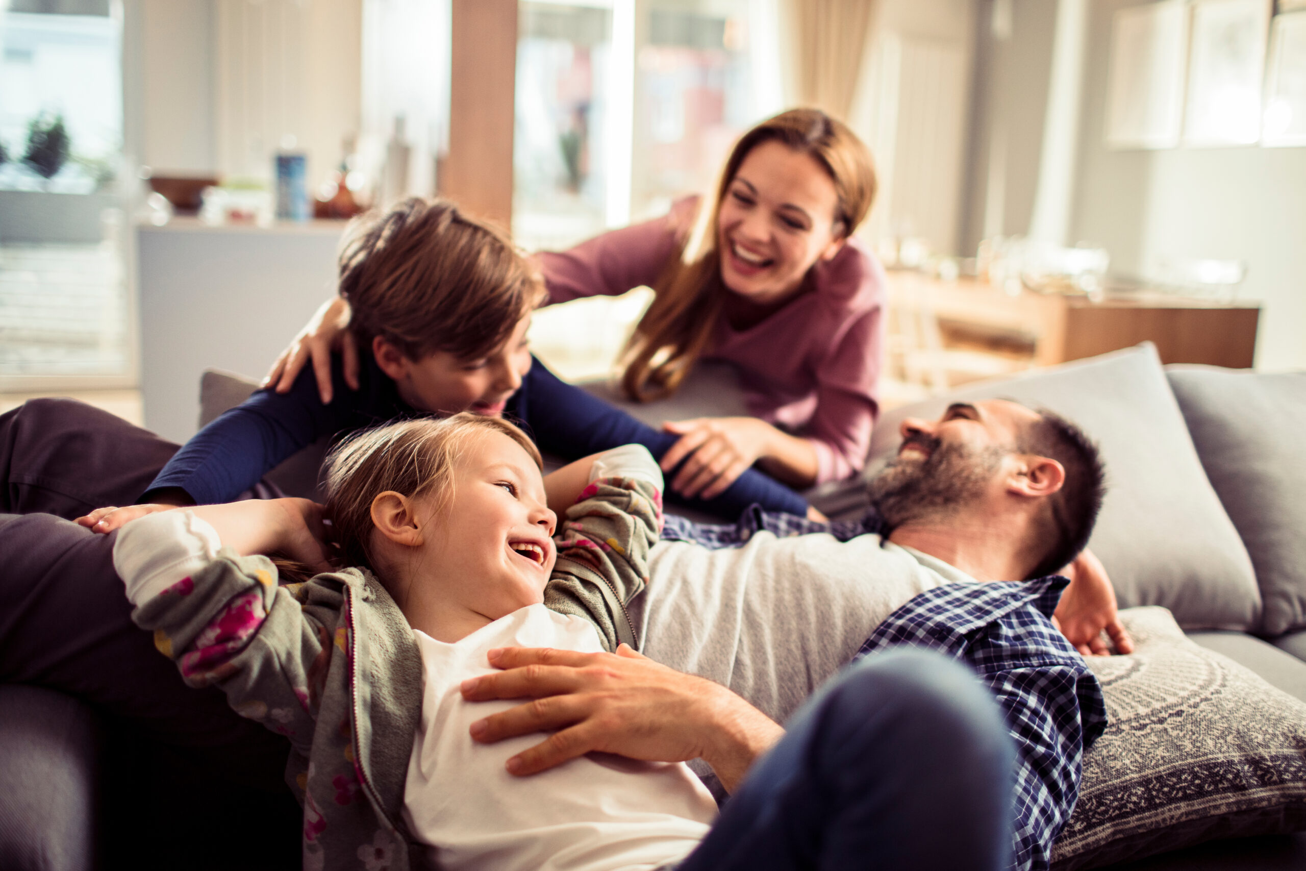 Free smoke alarms in Tennessee, showing a young family relaxing on the couch together at home.