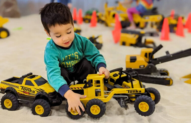 Little Diggers Franklin, TN, child plays in large sandbox with toy trucks