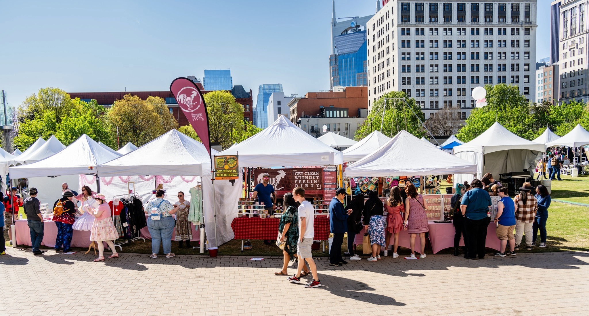 Festival vendors and shopping tents at the Nashville Cherry Blossom Festival in Public Square Park with downtown skyline in the background.
