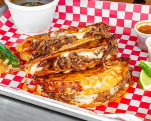 The Taco Shop in Cool Springs, Tennessee, serving Mexican birria with rich consommé for dipping in a casual dining setting