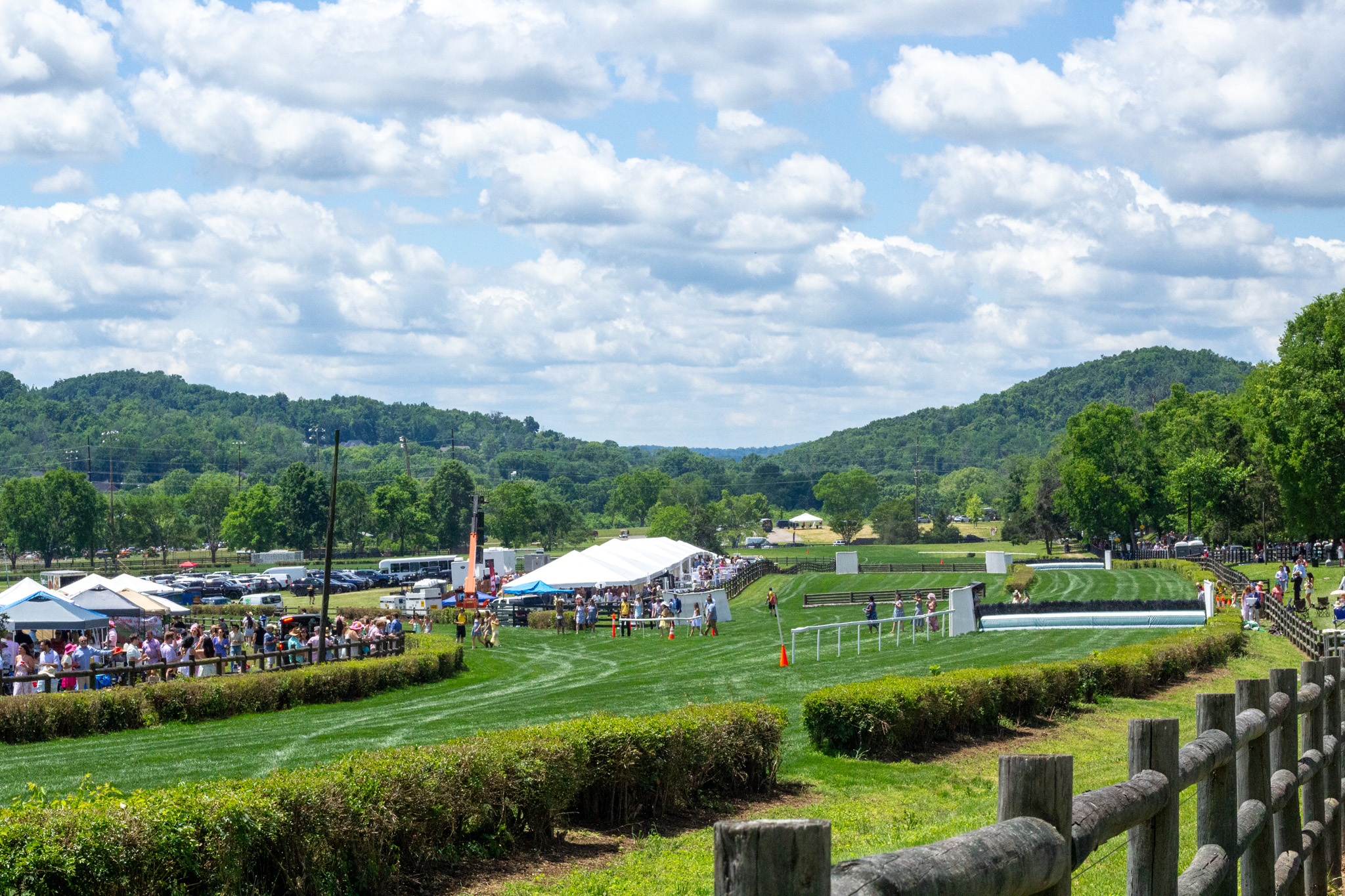 Iroquois Steeplechase Nashville race course at Percy Warner Park with tents, spectators, and rolling hills in the background.