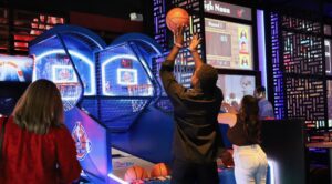 Kings Dining & Entertainment in Franklin, Tennessee game room featuring arcade games and basketball hoop machines with guests playing