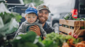 Father and son shopping fresh produce at a Tennessee farmers market for the Tennessee Farmers Market Trail. Photo by photographer Holly Rainey.