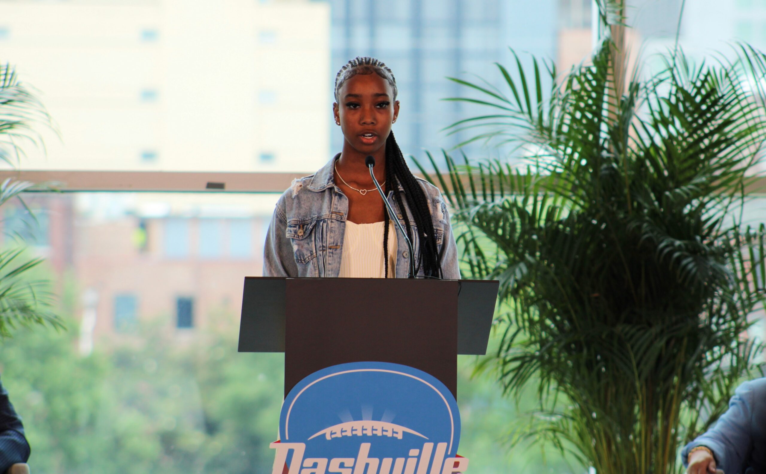 Titans Flag Football athlete speaking at a Nashville press conference about Super Bowl LXIV coming to New Nissan Stadium in 2030.