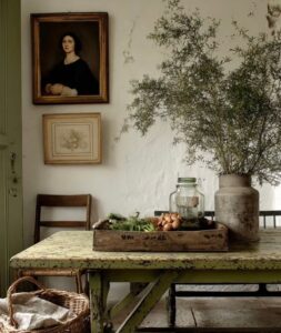 Antique farmhouse table with vintage artwork, pottery, and collected home decor from City Farmhouse in Franklin, TN.