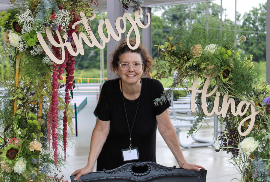 City Farmhouse, Kim Leggett at the Vintage Fling event beneath a floral display in Franklin, Tennessee.