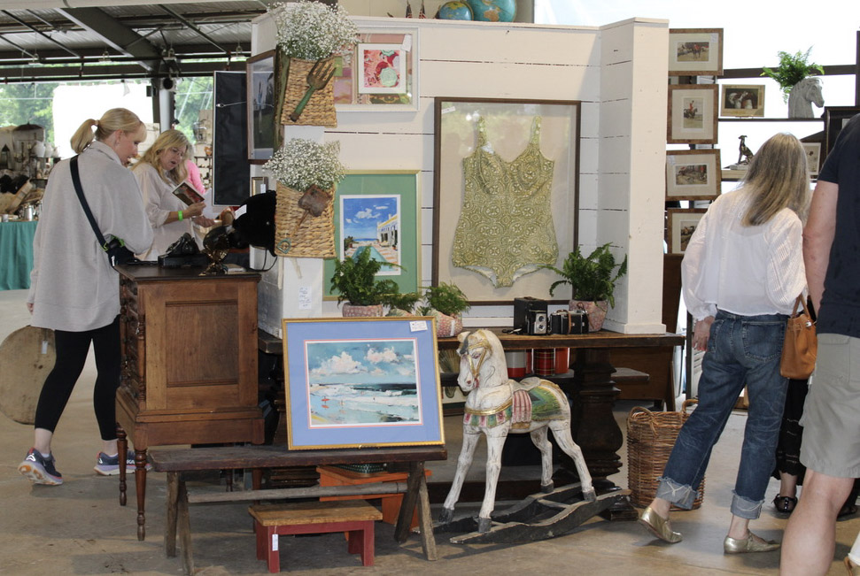City Farmhouse Vintage Fling shoppers browsing framed art, vintage decor, antique furniture, and a carousel horse in Franklin, Tennessee.