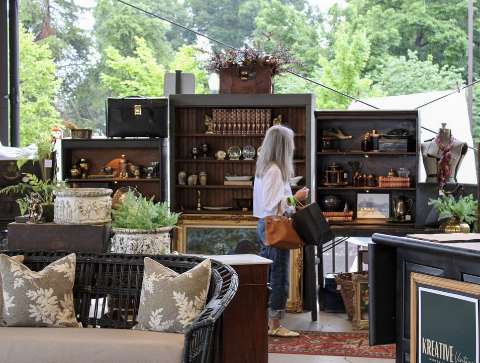 City Farmhouse Vintage Fling shopper browsing vintage furniture, antique books, plants, and home decor in Franklin, Tennessee.