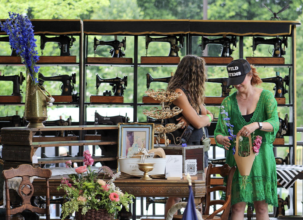 City Farmhouse Vintage Fling booth by The Wild Stems with floral arrangements and vintage sewing machines in Franklin, Tennessee.