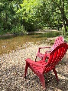 Guests enjoy wine flights and glasses at Crown Winery Leipers Fork while sitting by Leipers Creek in Franklin TN.