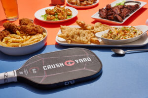 Food and appetizers served at Crush Yard in Brentwood, TN with a pickleball paddle in the foreground