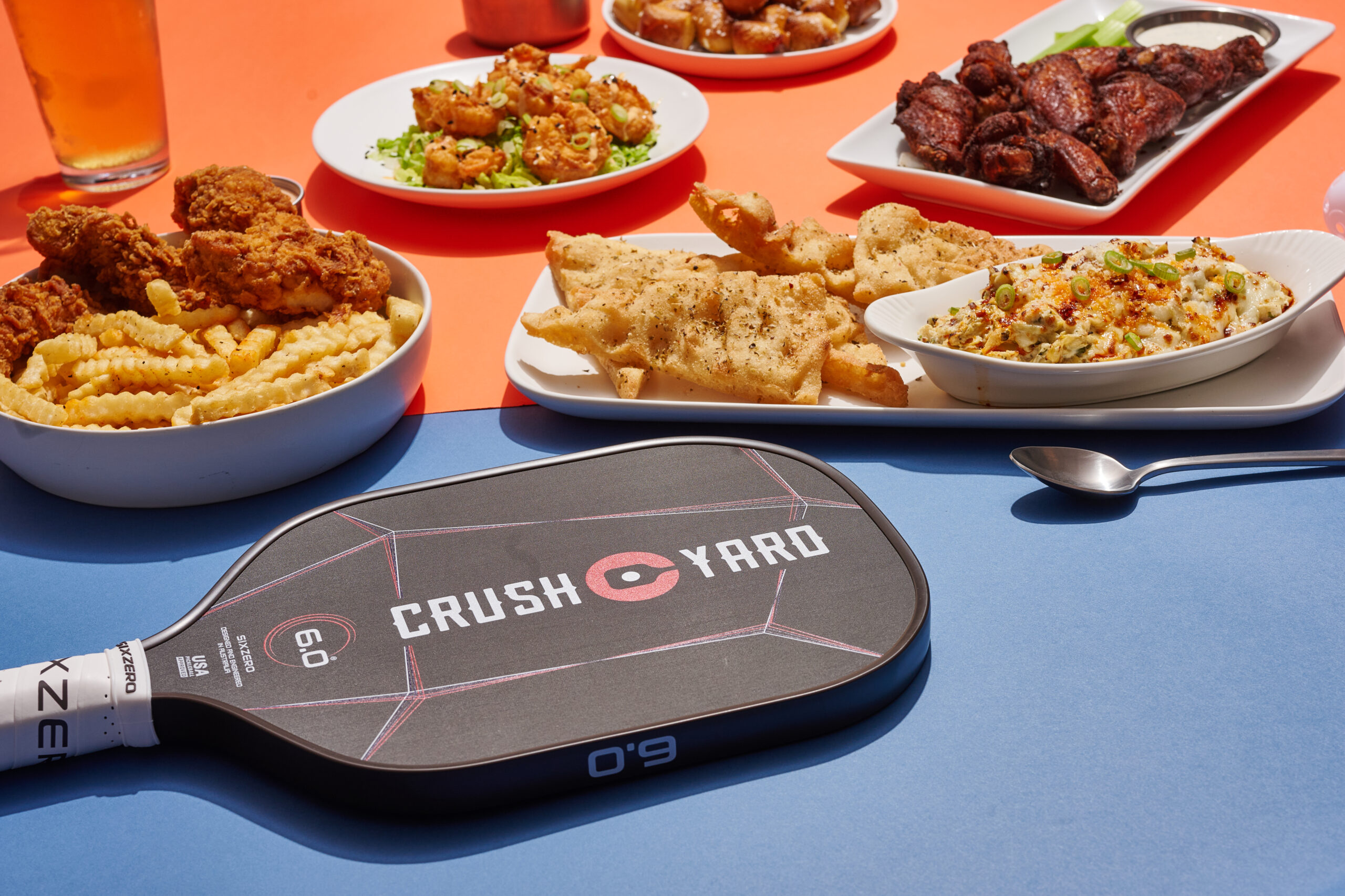 Food and appetizers served at Crush Yard in Brentwood, TN with a pickleball paddle in the foreground