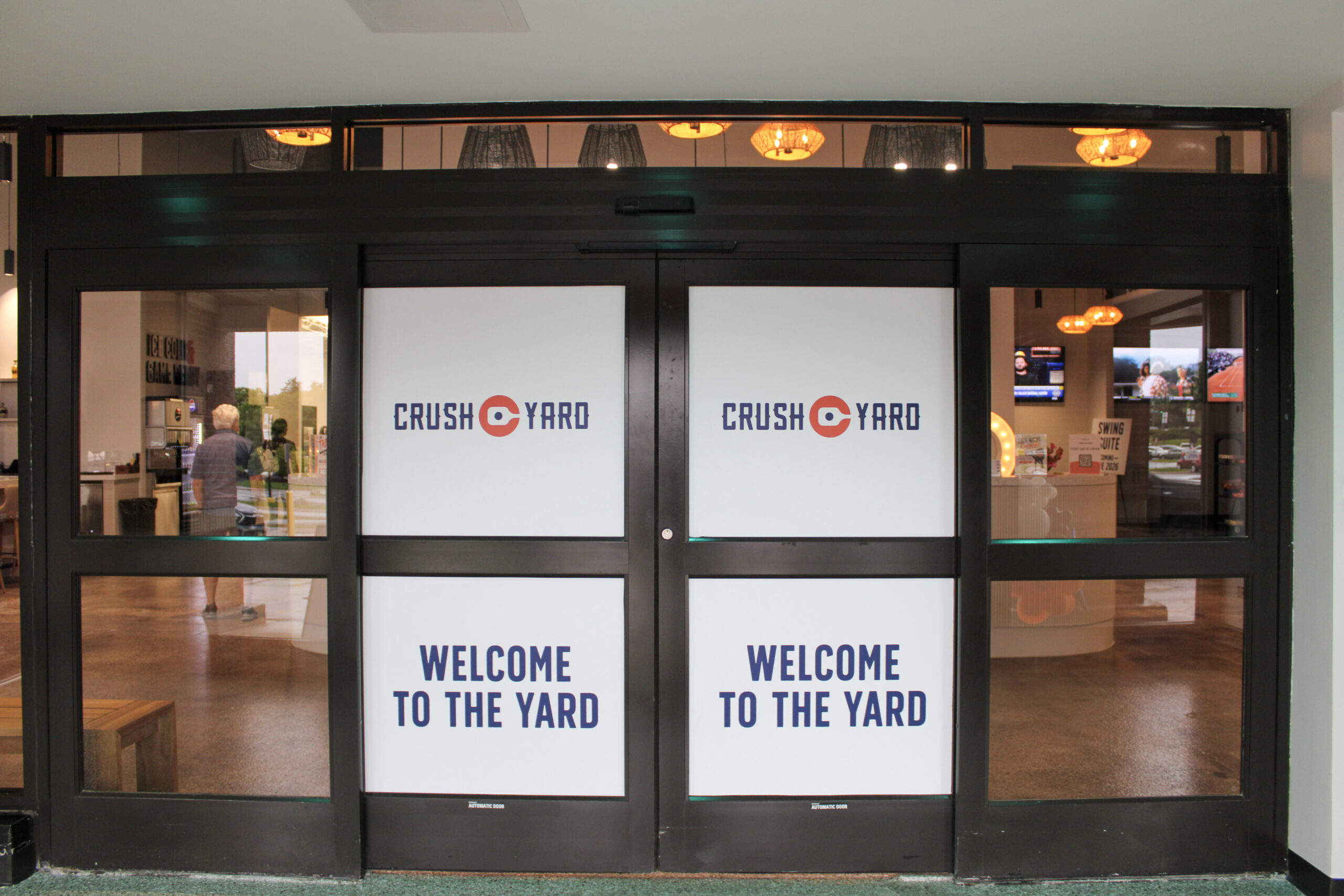 Entrance to Crush Yard Nashville in Brentwood, TN, with doors displaying the Crush Yard logo and “Welcome to the Yard” signage.