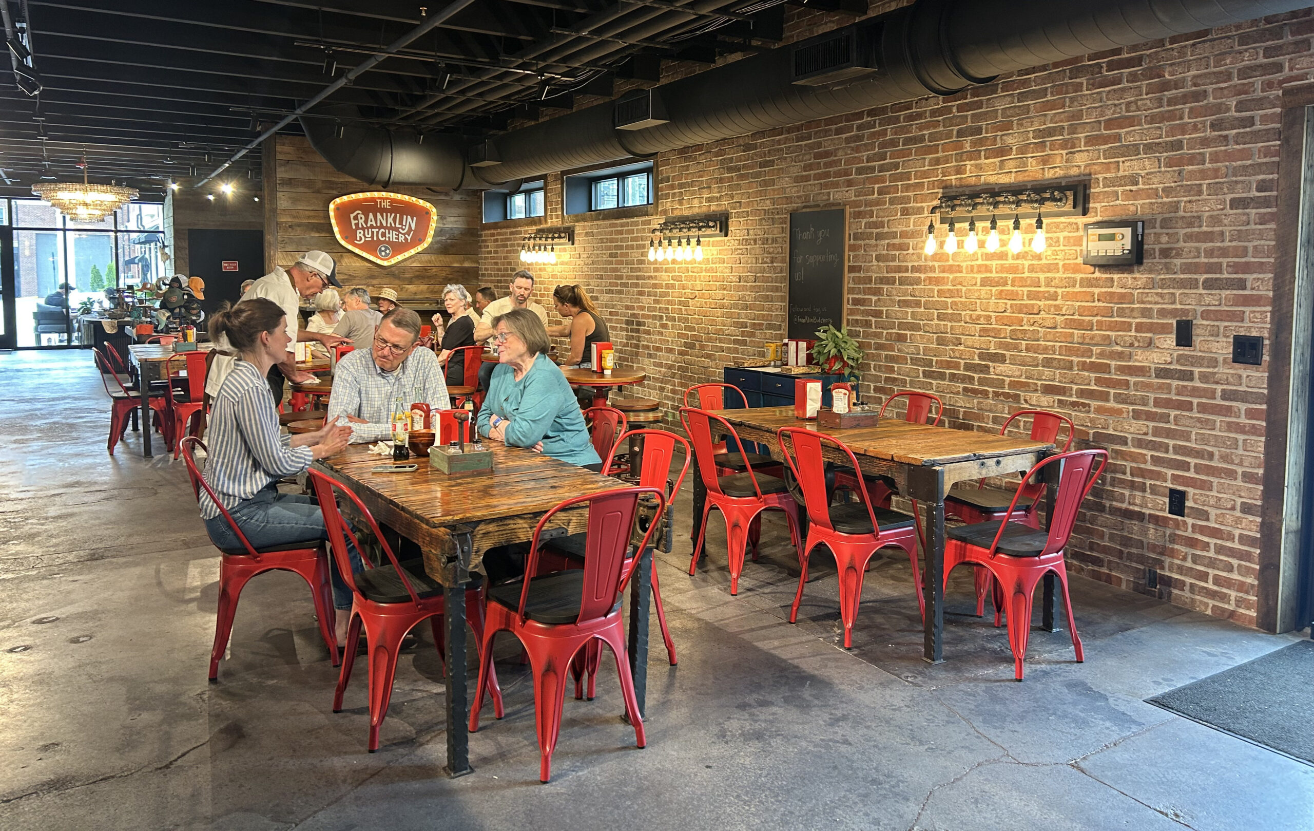 Dining room at The Franklin Butchery in downtown Franklin TN with guests seated at tables inside the butcher shop
