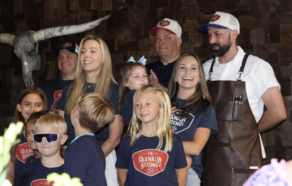 The Franklin Butchery owners, staff, and family members gathered inside the downtown Franklin butcher shop during the ribbon cutting celebration