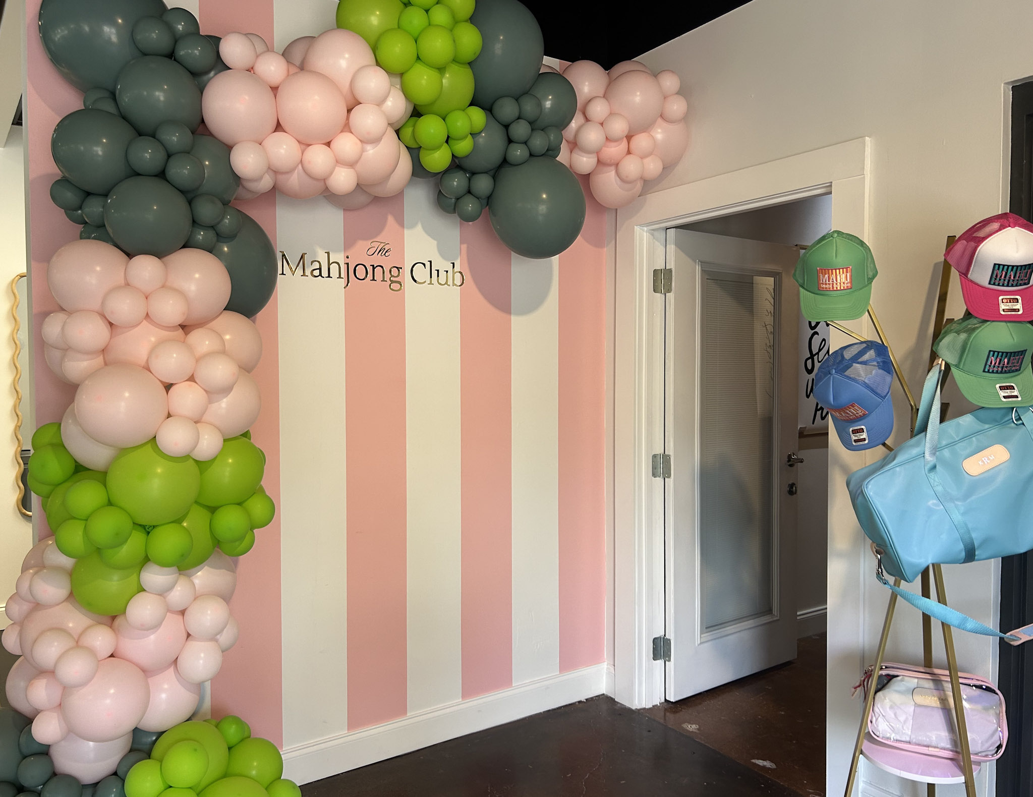 The Mahjong Club in Brentwood, TN, balloon display with hats and branded merchandise.