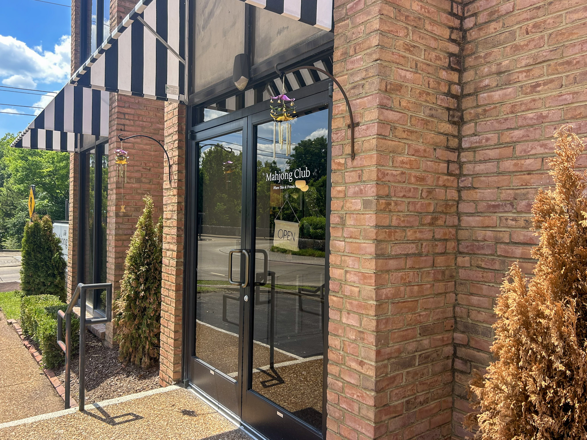 The Mahjong Club Brentwood, TN, front entrance with black and white striped awnings.