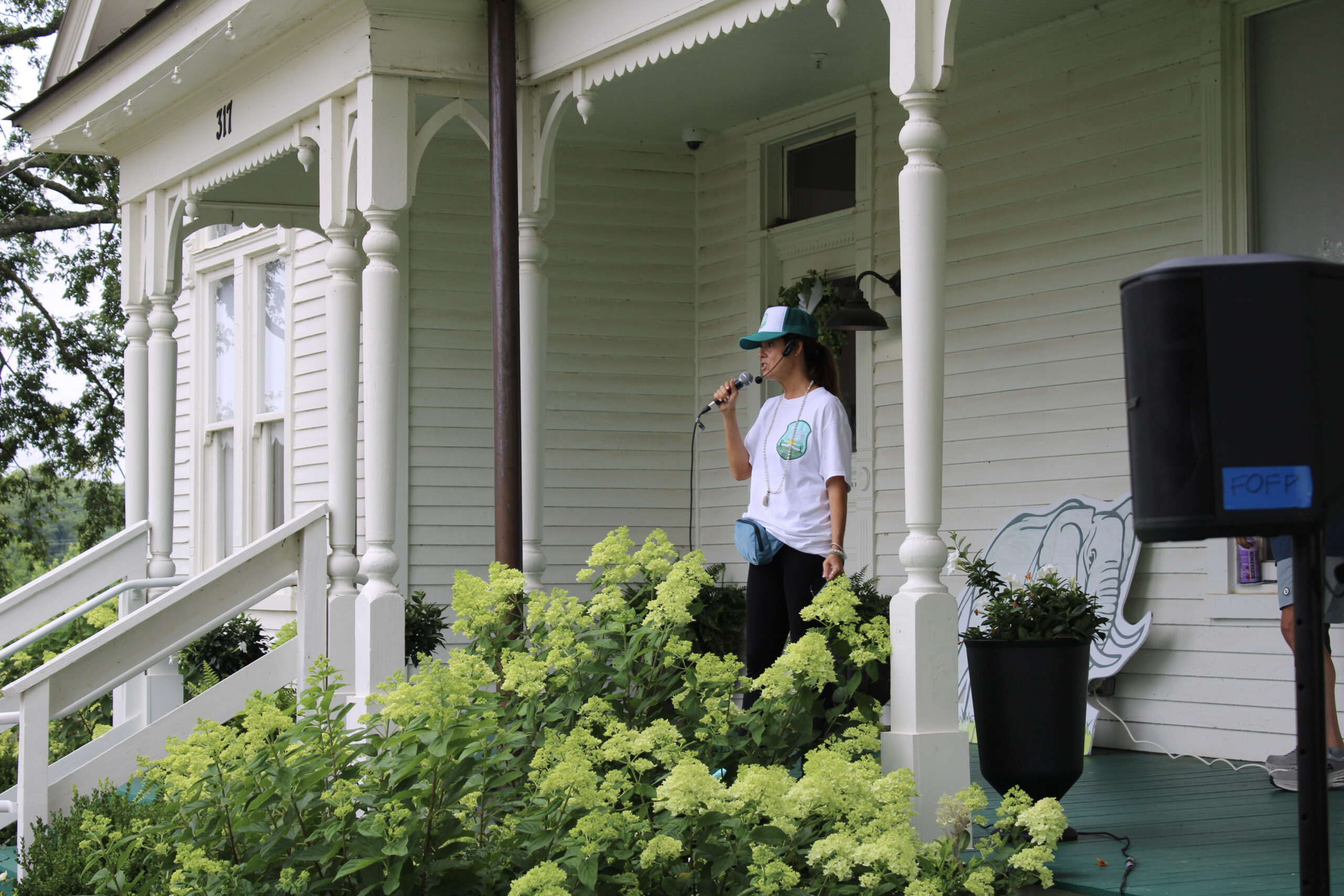 Yoga in the Park Franklin, TN lead ambassador Melissa Mooney-Lopez, founder of Be Well Mel, speaks from the porch at Harlinsdale Farm.