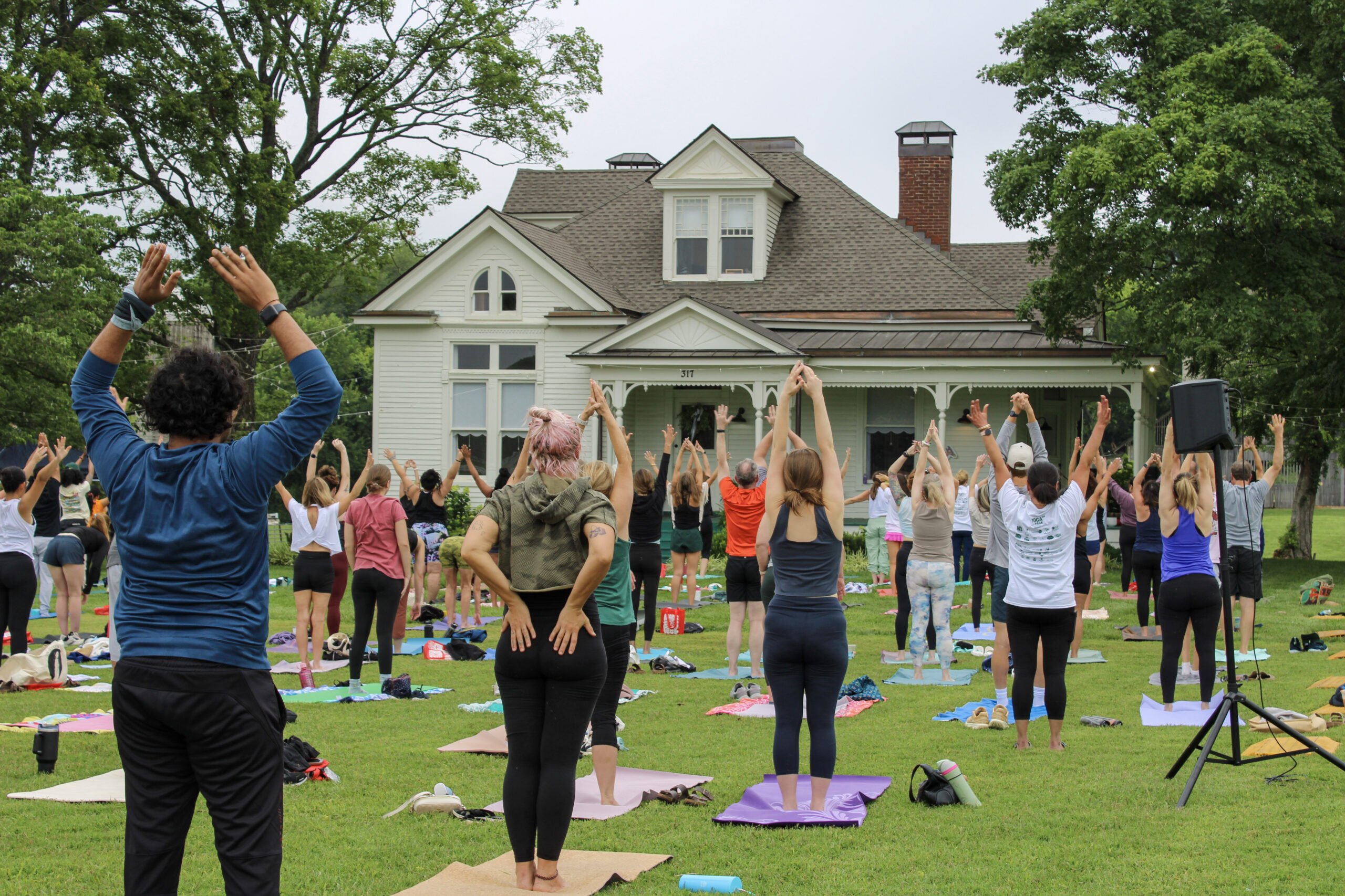 Yoga in the Park Franklin, TN participants practice yoga on the lawn at Harlinsdale Farm during a community wellness event.