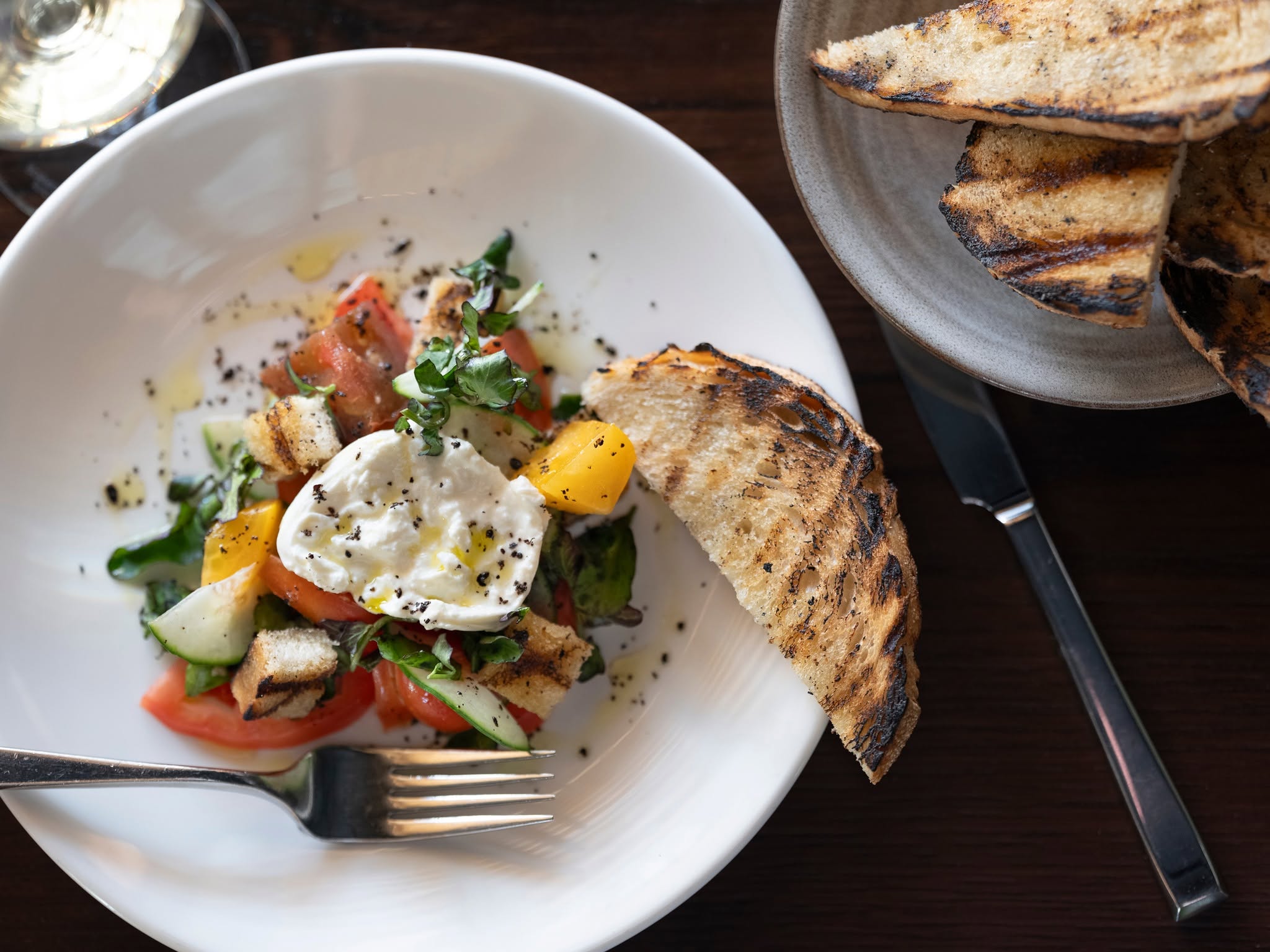 Brunch salad with burrata, tomatoes, cucumbers, and grilled bread at 1799 Kitchen and Bar Room in Franklin, TN.