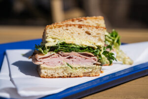 Chefs Aaron and Christen Clemins of Bill's Sandwich Palace | Nashville - Ham and Cheesy: Black Forest Ham, Havarti Cheese, Greens, Ponzu Dressing, Dijonnaise, Sesame Focaccia
